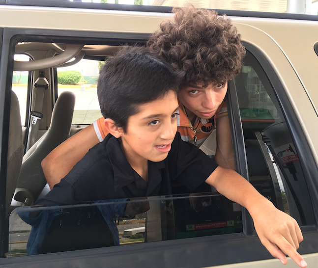 Ar�n, 13, and
        Chuch�n, 20, in rear window of Dr. Lorenzo's world-famous 2000
        Expedition